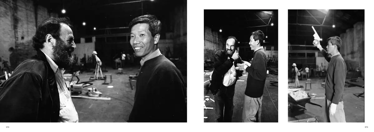 Two men laughing in the workshop, facing two smaller photographs of the team