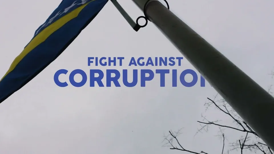 The flag of Bosnia and Herzegovina on a pole against a grey sky, with FIGHT AGAINST CORRUPTION in blue letters